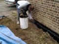 Application d'un badigeon d'étanchéité pour le traitement des murs contre terre