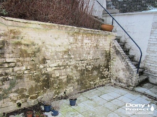 Terrasse avec mur contre terre abimé et humide